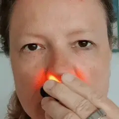 Usuário aplicando o LumiNasal Sinus Pro